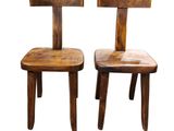 two wooden chairs sitting next to each other on a white surface