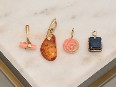 three pieces of jewelry sitting on top of a marble table