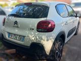a small white car parked on the side of the road