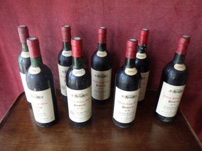 six bottles of red wine are lined up on a table