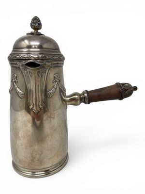 an antique silver coffee pot with a wooden handle on a white background