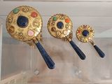 a display case with three mirrors and a pair of spoons