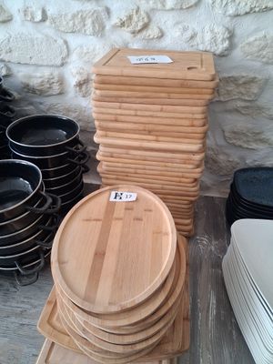 a stack of wooden plates and bowls sitting on a table