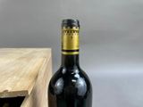 a bottle of wine sitting on a table next to a wooden box