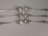 six silver spoons and a fork on a white surface