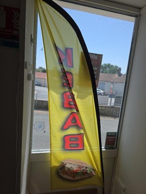 un grand drapeau jaune accroché à la fenêtre d'un restaurant