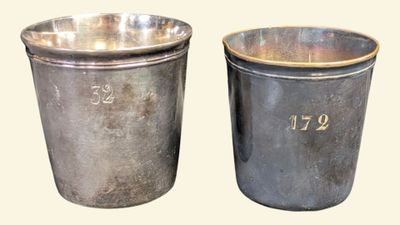 deux tasses en métal portant des chiffres, placées l'une à côté de l'autre