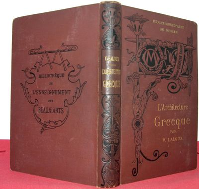 un vieux livre posé sur une table recouverte d'un tissu rouge