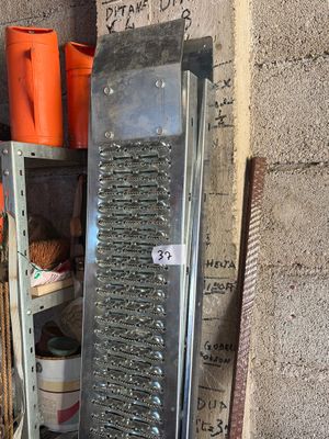 a metal grater sitting on a shelf in the corner of a room