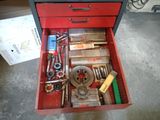 une boîte à outils rouge avec des outils sur le sol