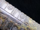 a close up of a knife with a lot of holes on it