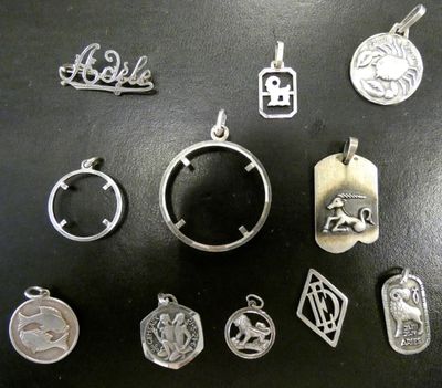 diverses breloques et pendentifs en métal argenté sur un fond noir