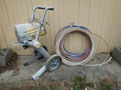a machine that is sitting on the ground next to a hose