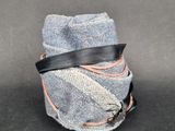 une image représentant un rouleau de tissu enveloppé dans un ruban noir