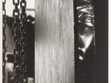 black and white photograph of a man peeking out of a box