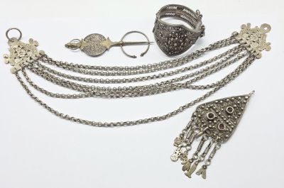 bijoux en argent posés sur une surface blanche, avec un fond blanc