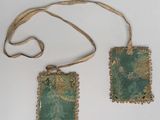 pair of green and gold embroidered purses on a white surface
