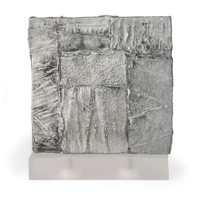 sculpture représentant un bloc de feuille d'argent sur une surface blanche