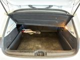 the trunk of a white car with the trunk open and a trash can in the trunk