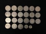 a lot of silver coins on a black surface
