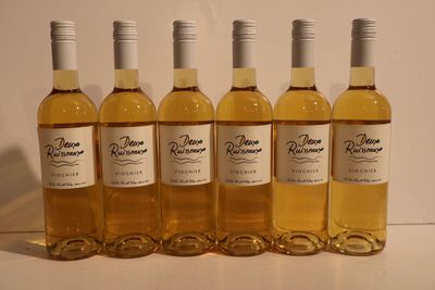 six bottles of wine are lined up on a table