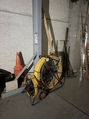 un tuyau jaune posé sur un chariot dans un garage