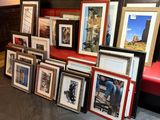 a lot of framed pictures on the floor of this room