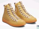 yellow converses with orange soles on a white background