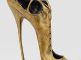 an image of a bronze shoe sculpture on a white background