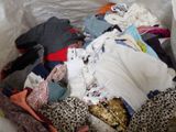 a pile of clothes in a plastic bag on the floor