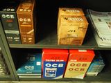 many boxes of cigarettes on a shelf in a store