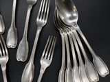 a lot of silver spoons and forks on a black table