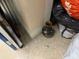 a trash can and a vase on the floor