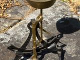 un petit bol en métal posé sur un socle, lui-même posé sur un rocher
