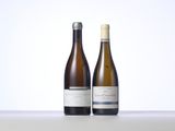 two bottles of white wine sitting on top of a table