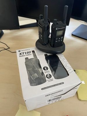 two walkie talkies sitting on top of a box