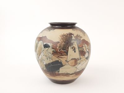 a vase with a painting on it sitting on a table