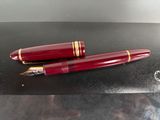 two red pens sitting on top of a black surface