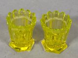 pair of yellow glass vases sitting on top of a white table