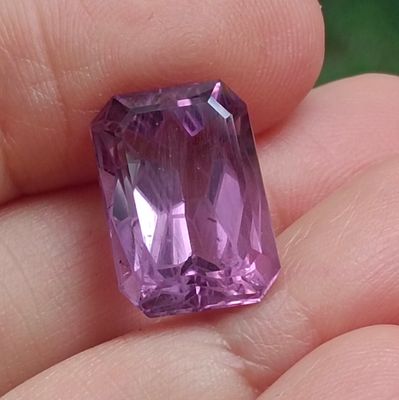 quelqu'un tient un diamant violet dans la main