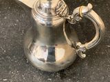 a silver tea pot sitting on a counter top