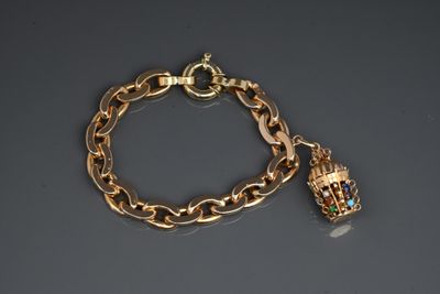 a close up of a gold chain bracelet with a bell charm