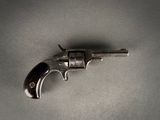 a close up of a gun on a table with a gray background