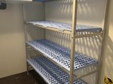 un rayonnage métallique muni d'étagères et d'un ventilateur dans une pièce