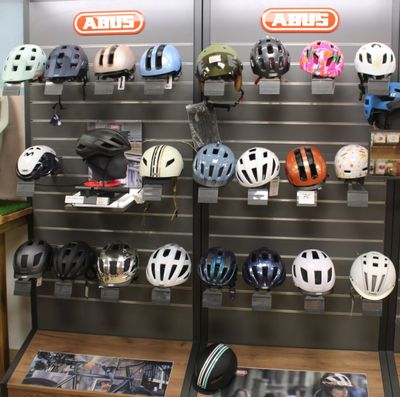 many helmets on display on the wall in the store