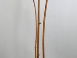 une sculpture représentant une personne assise au sommet d'un poteau en bois