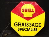 un panneau jaune et rouge sur lequel on peut lire « Graissage Spécialisé »