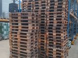 several stacks of wooden pallets stacked on top of each other in a warehouse