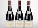 three bottles of wine are lined up on a white surface