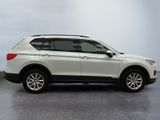 the white suv is parked in a room with a gray floor